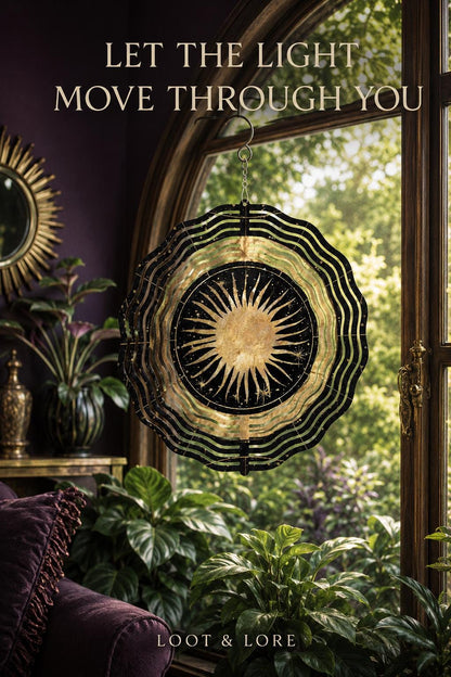 May include: A circular metal wind spinner featuring a gold sun design at the center surrounded by black and gold wavy patterns. The text LET THE LIGHT MOVE THROUGH YOU is printed above, and LOOT &amp; LORE is printed at the bottom of the image.