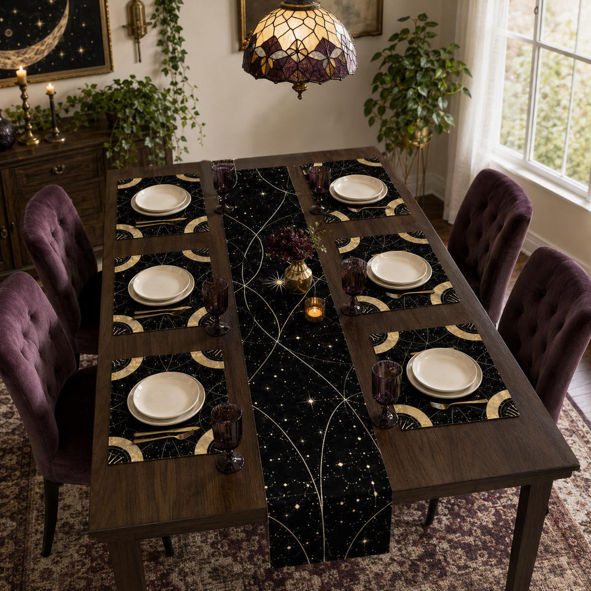 May include: A dining table set featuring a black table runner and six matching placemats, all decorated with a gold celestial pattern of stars and curved lines. Each place setting includes a white ceramic plate and a dark purple glass goblet.