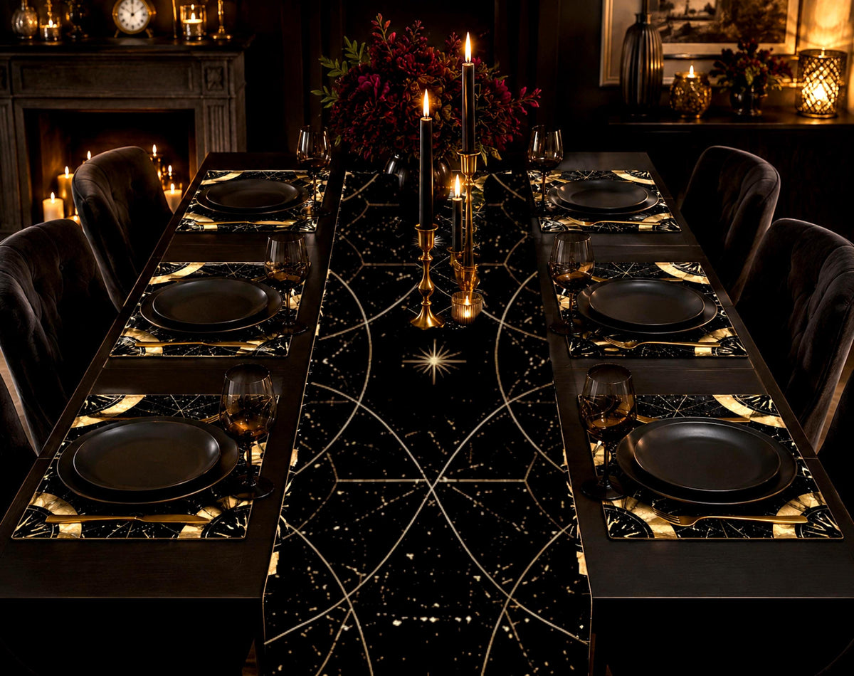May include: A dining table set featuring a black table runner and matching placemats decorated with gold celestial patterns, including stars and geometric lines. The setting includes matte black plates, gold-toned cutlery, and black candles.