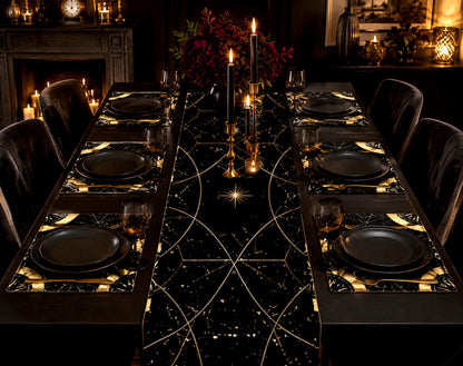 May include: A dining table set featuring a black table runner and matching placemats decorated with gold celestial patterns, including stars and geometric lines. The setting includes matte black plates, gold-toned cutlery, and black candles.